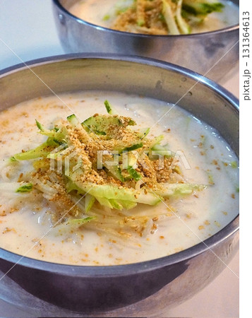 Kungguksu, a savory Korean cold noodle dish served in a rich broth, topped with fresh vegetables and garnished with seaweed. Perfect for summer meals, capturing the essence of Korean comfort food. Kungguksu, a savory Korean cold noodle dish served in a rich broth, topped with fresh vegetables and garnished with seaweed. Perfect for summer meals, capturing the essence of Korean comfort food. 131364613