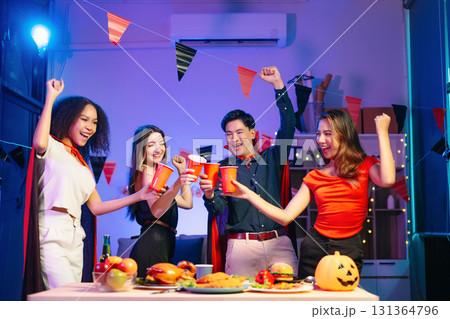 Joyful office Halloween party with coworkers in costumes, celebrating with drinks and laughter, fostering teamwork 131364796