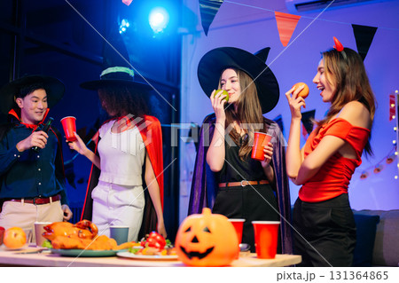 Joyful office Halloween party with coworkers in costumes, celebrating with drinks and laughter, fostering teamwork 131364865