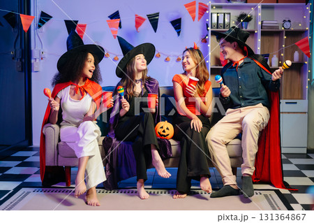 Joyful office Halloween party with coworkers in costumes, celebrating with drinks and laughter, fostering teamwork Joyful office Halloween party with coworkers in costumes, celebrating with drinks and laughter, fostering teamwork 131364867