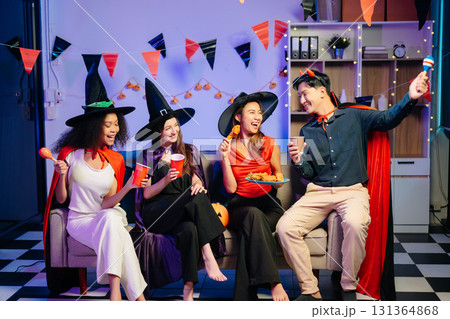 Joyful office Halloween party with coworkers in costumes, celebrating with drinks and laughter, fostering teamwork Joyful office Halloween party with coworkers in costumes, celebrating with drinks and laughter, fostering teamwork 131364868