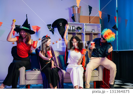 Joyful office Halloween party with coworkers in costumes, celebrating with drinks and laughter, fostering teamwork Joyful office Halloween party with coworkers in costumes, celebrating with drinks and laughter, fostering teamwork 131364875