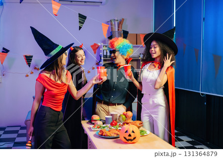 Joyful office Halloween party with coworkers in costumes, celebrating with drinks and laughter, fostering teamwork 131364879