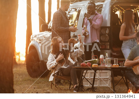 By the campfire. Group of friends are having fun together in the forest 131364941