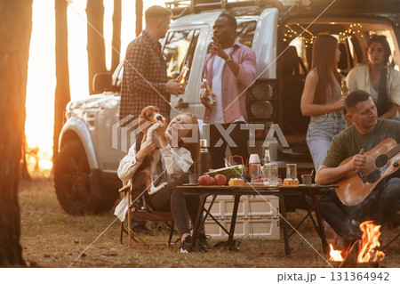 By the campfire. Group of friends are having fun together in the forest 131364942