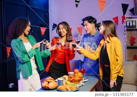 Celebration with friends enjoying food, drinks, and laughter at a lively house party. 131365177