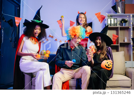 Joyful office Halloween party with coworkers in costumes, celebrating 131365246