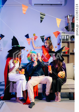 Joyful office Halloween party with coworkers in costumes, celebrating 131365314