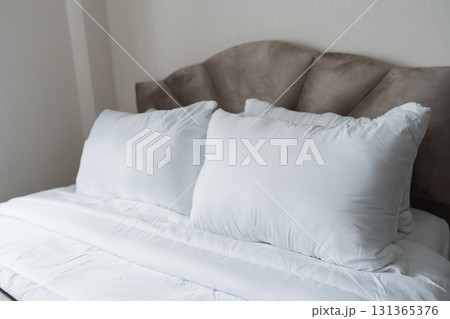 Cozy and Comfortable Bed with Soft White Pillows and Smooth Blanket in a Calm Bedroom Setting for Relaxation and Restful Sleep 131365376