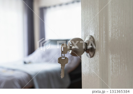 Modern Door Handle with Keys Hanging, Bright Bedroom Interior Revealing Soft Textiles, Natural Light Streaming Through Windows Modern Door Handle with Keys Hanging, Bright Bedroom Interior Revealing Soft Textiles, Natural Light Streaming Through Windows 131365384