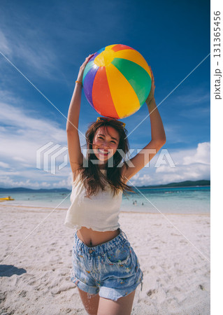 浜辺でビーチボールを持つ夏服の女性 浜辺でビーチボールを持つ夏服の女性 131365456