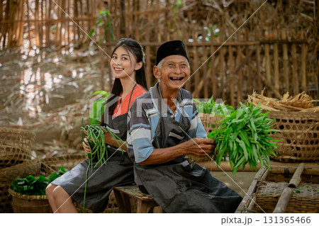 Smiling Farmers in a Traditional Setting Surrounded by Fresh, Colorful Vegetables Smiling Farmers in a Traditional Setting Surrounded by Fresh, Colorful Vegetables 131365466
