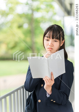参考書,教科書,問題集を読みながら通学する受験生の女子高生,中学生,高校生 参考書,教科書,問題集を読みながら通学する受験生の女子高生,中学生,高校生 131366263