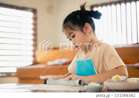 Young Girl Engaged in Creative Cooking Activity at Home with Passion for Culinary Skills and Learning in a Bright, Cozy Kitchen Environment 131366362