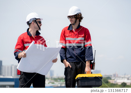 Two engineer checking solar energy system looking blueprint together. 131366717