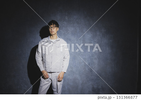 腕組みをする作業服の男性 131366877