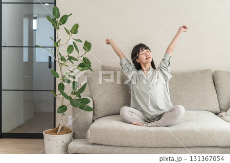 家のソファでリラックス・リフレッシュをする若いアジア人女性（モーニングルーティーン） 131367054