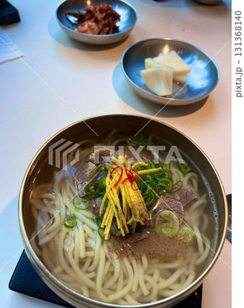 A comforting bowl of salguksu, Korean knife-cut noodles served in a light and savory broth with tender chicken and fresh vegetables. Perfect for a warm, satisfying meal. A comforting bowl of salguksu, Korean knife-cut noodles served in a light and savory broth with tender chicken and fresh vegetables. Perfect for a warm, satisfying meal. 131368140