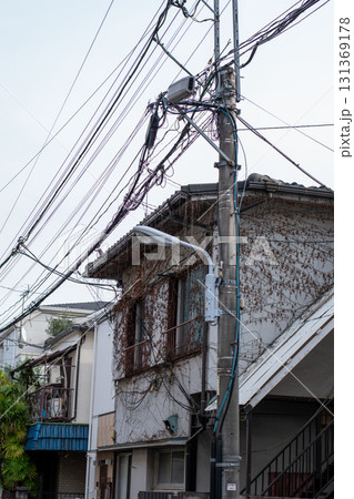 Old Japanese residential house with ivy walls and electric power lines Old Japanese residential house with ivy walls and electric power lines 131369178