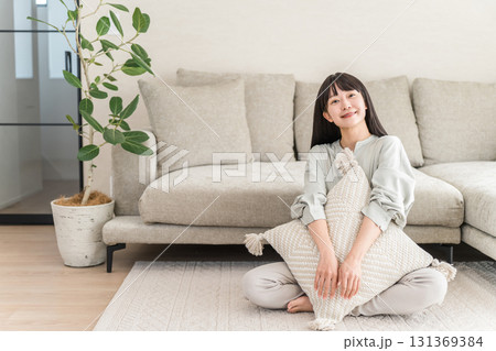 自宅のリビングでくつろぐ笑顔の若いアジア人女性 自宅のリビングでくつろぐ笑顔の若いアジア人女性 131369384