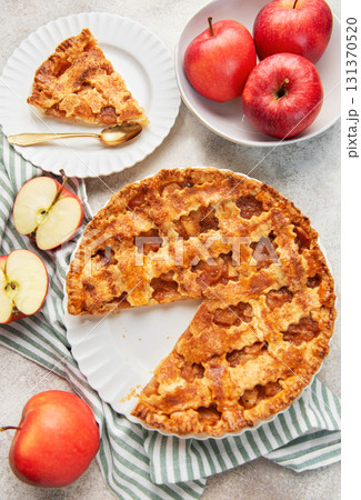 Homemade apple pie with a slice and fresh apples 131370520