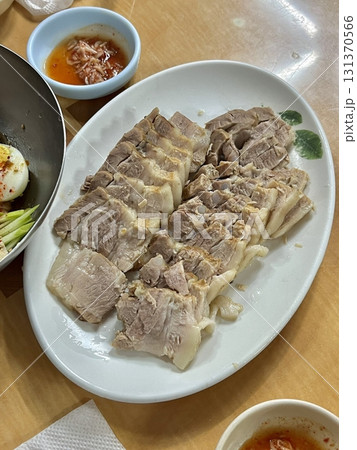 Suyuk, a traditional Korean dish of boiled pork slices, tender and juicy, often served with salted shrimp sauce, garlic, and ssamjang. Perfect for wrapping in lettuce for a flavorful, balanced bite. Suyuk, a traditional Korean dish of boiled pork slices, tender and juicy, often served with salted shrimp sauce, garlic, and ssamjang. Perfect for wrapping in lettuce for a flavorful, balanced bite. 131370566