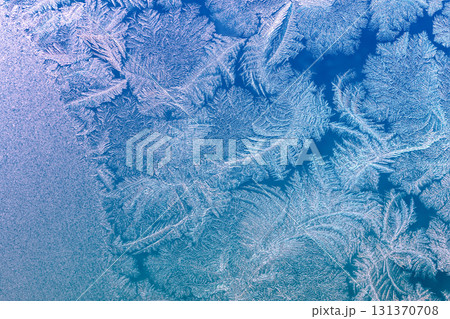 Natural texture of ice on a frozen window in blue light. Christmas background 131370708