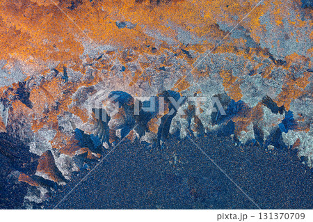 Natural ice texture on the frozen window in colorful light. Blue orange gradient color. Abstract Christmas background 131370709