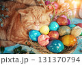Cute ginger cat lying near basket with colorful easter eggs 131370794