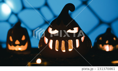 Glowing Halloween pumpkins with candles and lights in silhouette at night 131370861