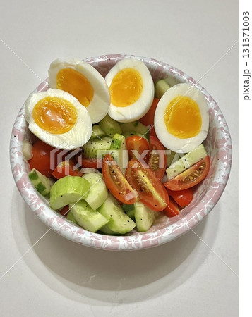 Fresh vegetable salad with a vibrant mix of greens, cherry tomatoes, cucumbers, and bell peppers. Crisp, colorful, and packed with vitamins, this salad makes a healthy, delicious meal or side. 131371003