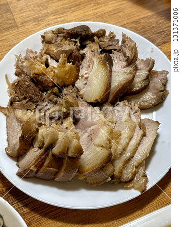 Suyuk, a traditional Korean dish of boiled pork slices, tender and juicy, often served with salted shrimp sauce, garlic, and ssamjang. Perfect for wrapping in lettuce for a flavorful, balanced bite. 131371006