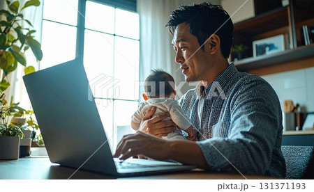 赤ちゃんを抱っこして育児をしながらオンラインで仕事をする親 赤ちゃんを抱っこして育児をしながらオンラインで仕事をする親 131371193