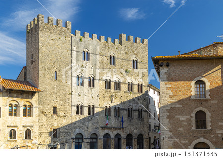 Massa Marittima, Palazzo del Podesta with crenellated walls under blue sky Massa Marittima, Palazzo del Podesta with crenellated walls under blue sky 131371335