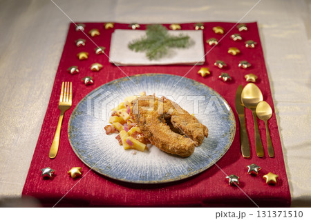 Fried carp serving on Christmas table with potato salad Fried carp serving on Christmas table with potato salad 131371510