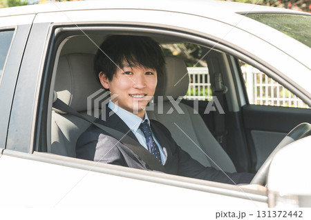 車を運転するスーツ姿の若い男性ビジネスマン 車を運転するスーツ姿の若い男性ビジネスマン 131372442