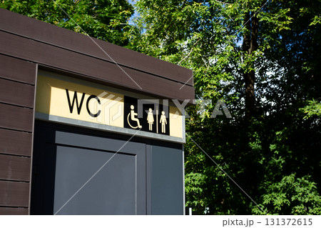 Restroom sign offering easy access for all, with a wheelchair symbol and distinct male and female icons. Practical element of urban infrastructure ensuring comfort and safety for the public Restroom sign offering easy access for all, with a wheelchair symbol and distinct male and female icons. Practical element of urban infrastructure ensuring comfort and safety for the public 131372615