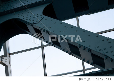 Detailed view of steel structural beams with rivets and bolts, showcasing modern engineering and architectural design. Ideal for projects focused on innovation, construction, and material strength Detailed view of steel structural beams with rivets and bolts, showcasing modern engineering and architectural design. Ideal for projects focused on innovation, construction, and material strength 131372634