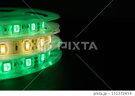 Close-up of LED strip reels glowing green and warm white Close-up of LED strip reels glowing green and warm white 131372654