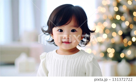 クリスマス　ぼやけたクリスマスツリー背景のかわいい女の子の赤ちゃん 131372722