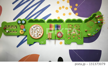 Interactive wall-mounted sensory play panel for kids, shaped like a crocodile, featuring gears, mazes, musical instruments, and bead games for hands-on learning and fun. Interactive wall-mounted sensory play panel for kids, shaped like a crocodile, featuring gears, mazes, musical instruments, and bead games for hands-on learning and fun. 131373079