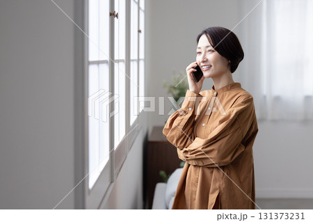 スマートフォンで会話を楽しむ笑顔のミドル女性 131373231