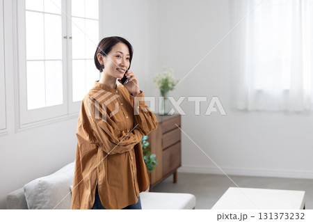 スマートフォンで会話を楽しむ笑顔のミドル女性 131373232