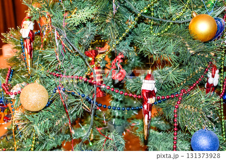Decorations New Year tree. Tinsel and toys, balls and other decorations on the Christmas Christmas tree standing in the open air. Decorations New Year tree. Tinsel and toys, balls and other decorations on the Christmas Christmas tree standing in the open air. 131373928