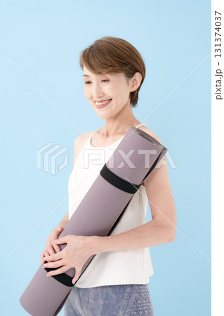 ヨガマットを持つ女性　 131374037