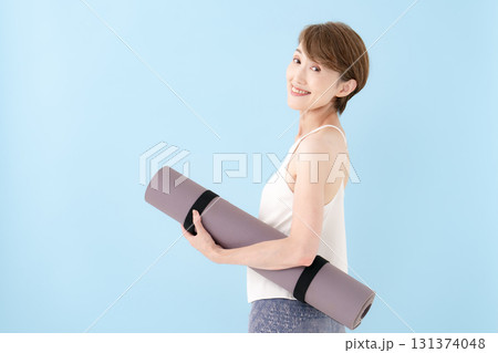 ヨガマットを持つ女性　 131374048