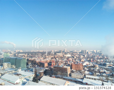 Winter town. Frosty sunny day in the city. Snow on the streets and smoke from the boiler rises. Frost and sun, a wonderful day 131374128