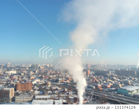 Winter town. Frosty sunny day in the city. Snow on the streets and smoke from the boiler rises. Frost and sun, a wonderful day Winter town. Frosty sunny day in the city. Snow on the streets and smoke from the boiler rises. Frost and sun, a wonderful day 131374129