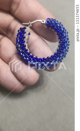 Handmade round earrings made of seed beads and glass beads on a light background 131374655