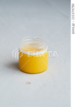 colorful acrylic paint in jar, grey dirty background,  artists materials photography 131374790